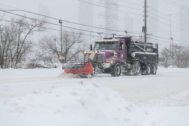 Toronto, ON, Kanada - 27 Şubat 2025: Kar küreme aracı kar fırtınası sırasında yolu temizliyor.