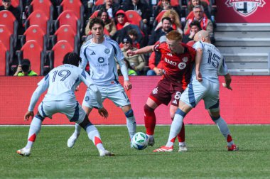Toronto, ON, Kanada - 15 Mart 2025: # 8 Toronto FC oyuncusu Matty Longstaff BMO Field 'da oynanan MLS maçı sırasında Chicago Fire FC oyuncularına karşı mal bulundurmak için dövüşür. 1: 2 Chicago İtfaiyesi kazandı.)