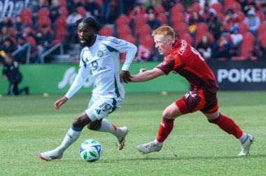Toronto, ON, Kanada - 15 Mart 2025: # 19 Jonathan Bamba Chicago İtfaiye FC Toronto FC 'li Matty Longstaff' ın yanından BMO Field 'da oynanan MLS maçında geçiyor. Sayı 1: 2, Chicago İtfaiyesi kazandı.)
