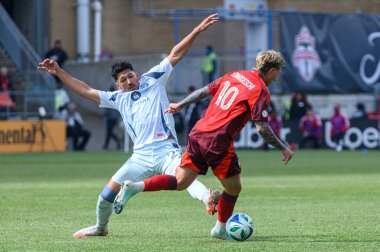 Toronto, ON, Kanada - 15 Mart 2025: # 10 Toronto FC 'den Federico Bernardeschi, BMO Field' da oynanan MLS maçında Chicago Fire FC 'den 22 numara Mauricio Pineda' yı geçti. Sayı 1: 2, Chicago İtfaiyesi kazandı.)