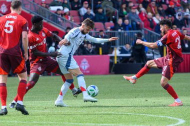 Toronto, ON, Kanada - 15 Mart 2025: Chicago İtfaiye Teşkilatı 'ndan Philip Zinckernagel # 11 forvet oyuncusu, üç Toronto FC defans oyuncusu BMO Field' da oynanan maçta onu engellemeye çalışırken ele geçirmeye çalışıyor. Sayı 1: 2, Chicago İtfaiyesi kazandı.)