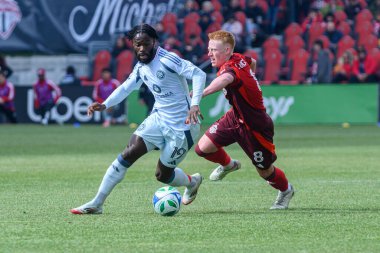Toronto, ON, Kanada - 15 Mart 2025: # 19 Jonathan Bamba Chicago İtfaiye FC Toronto FC 'li Matty Longstaff' ın yanından BMO Field 'da oynanan MLS maçında geçiyor. Sayı 1: 2, Chicago İtfaiyesi kazandı.)