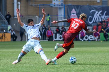 Toronto, ON, Kanada - 15 Mart 2025: # 10 Toronto FC 'den Federico Bernardeschi, BMO Field' da oynanan MLS maçında Chicago Fire FC 'den 22 numara Mauricio Pineda' yı geçti. Sayı 1: 2, Chicago İtfaiyesi kazandı.)