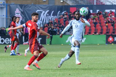 Toronto, ON, Kanada - 15 Mart 2025: Jonathan Osorio (# 21), Toronto FC 'nin orta saha oyuncusu, Chicago Fire FC forveti Jonathan Bamba ile BMO Field' da oynanan maçta mücadele etmektedir. Sayı 1: 2, Chicago İtfaiyesi kazandı.)