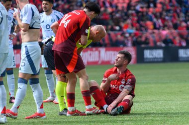 Toronto, ON, Kanada - 15 Mart 2025: Hakem Allen Chapman, BMO Field 'da Chicago Fire FC' ye karşı oynanan karşılaşma sırasında Toronto FC 'nin 5 numaralı Kevin Long defansını yerde yatarken kontrol ediyor. Sayı 1: 2, Chicago İtfaiyesi kazandı.)