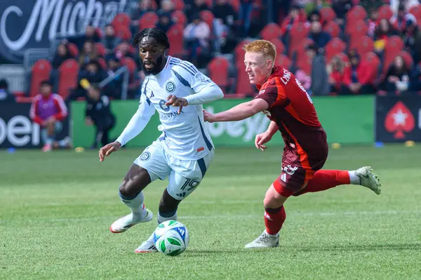 Toronto, ON, Kanada - 15 Mart 2025: # 19 Jonathan Bamba Chicago İtfaiye FC Toronto FC 'li Matty Longstaff' ın yanından BMO Field 'da oynanan MLS maçında geçiyor. Sayı 1: 2, Chicago İtfaiyesi kazandı.)