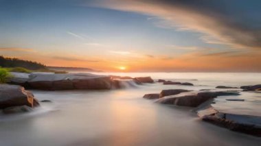 Ufuk güzel bir manzara, sahildeki su yavaşça akıyor, bölgede günbatımı ışığı ve taşlarla birlikte, sosyal medya, pazarlama, reklamlar, alıntılar, arka planlar vb.