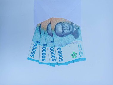 Beyaz arka planda bir tomar para. THR Kurban Bayramı, Maaş, Bonus konsepti