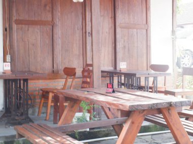 the chairs and table at cafe. indonesia, meja kayu dan kursi kayu dan nomor meja di restoran kopi kampung ambarukmo kokambar, yogyakarta, nampak kuat, dengan desain menarik, outdoor meja dan kursi luar ruangan, kayu jati dan kayu yang kuat