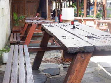 the chairs and table at cafe. indonesia, meja kayu dan kursi kayu dan nomor meja di restoran kopi kampung ambarukmo kokambar, yogyakarta, nampak kuat, dengan desain menarik, outdoor meja dan kursi luar ruangan, kayu jati dan kayu yang kuat
