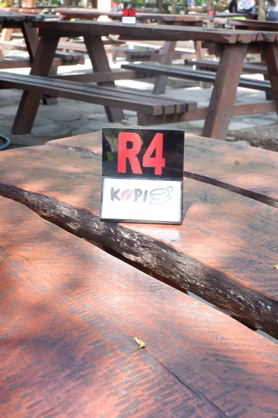 the chairs and table at cafe. indonesia, meja kayu dan kursi kayu dan nomor meja di restoran kopi kampung ambarukmo kokambar, nampak kuat, dengan desain menarik, outdoor meja dan kursi luar ruangan, kayu jati dan kayu yang kuat