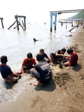 Sahilde suda oynayan bir grup insan. 