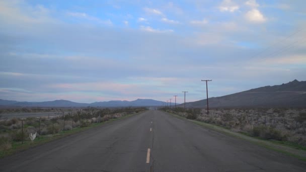 容赦のない砂漠の広がりを横断する孤独な道 — ストック動画