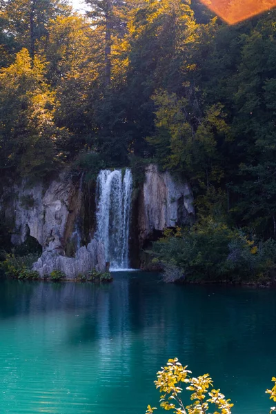 Beautiful landscape of the waterfall in the mountains with green leaves and trees in sunny day, Croatia.