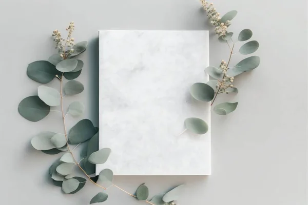 Marble paper blank, eucalyptus branches on pastel gray background.