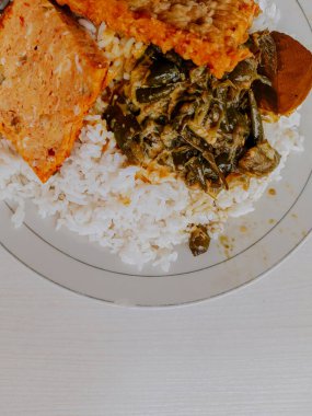 Nasi Padang ya da Padang Rice, Endonezya 'nın ünlü geleneksel yemeğidir. Biftekli pilav, manyok yaprağı ve yeşil biber ezmesi..