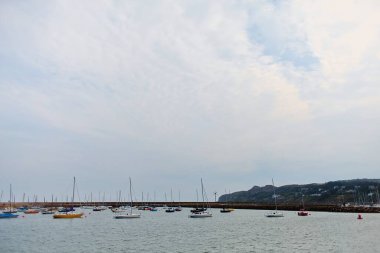 Howth marinasında yelkenli sürüyor. Howth, Dublin, İrlanda 'da bulutlu bir gün. 
