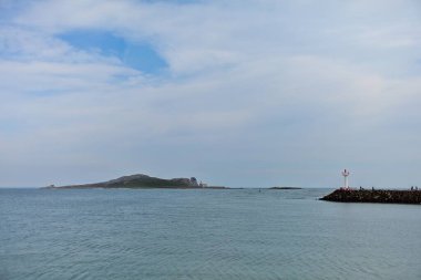 Deniz feneri. Limanda ve marinada bulutlu bir günde Howth, Dublin, İrlanda. 