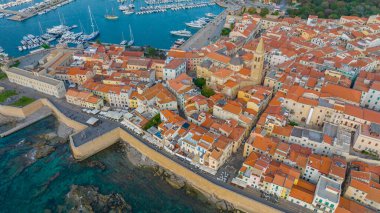 Sardinya 'daki eski Alghero kasabasının hava manzarası. Güneşli bir günde insansız hava aracıyla çekilmiş bir fotoğraf. Eski şehrin panoramik manzarası ve Alghero limanı, Sardunya, İtalya.
