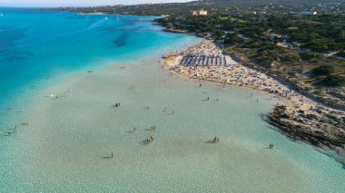 Güneşli yaz gününde La Pelosa sahilinin havadan görünüşü. Stintino, Sardunya Adası, İtalya. Kumsalın insansız hava aracı görüntüsü, insanlarla oynamak, açık mavi deniz..