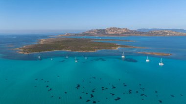 Stintino yakınlarındaki Isola Piana adasının ve Spiaggia La Pelosa plajının havadan çekilmiş fotoğrafı. Dağlık ada, mavi su ve berrak gökyüzü. Sardinya 'nın kuzeybatı kısmı, Sassari ili, İtalya.
