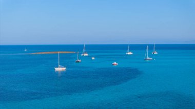 Sardinya 'nın kuzeybatısındaki Spiagga La Pelosa plajı yakınlarındaki yatlar. Stintino köyü, Sassari ili, Sardinya, İtalya. Yaz, güneşli gün, mavi su.