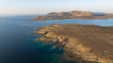Stintino yakınlarındaki Isola Piana adasının ve Spiaggia La Pelosa plajının havadan çekilmiş fotoğrafı. Dağlık ada, mavi su ve berrak gökyüzü. Sardinya 'nın kuzeybatı kısmı, Sassari ili, İtalya.