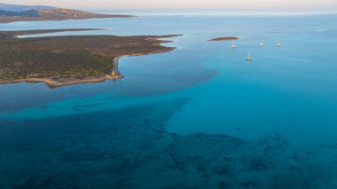 Stintino yakınlarındaki Isola Piana adasının ve Spiaggia La Pelosa plajının havadan çekilmiş fotoğrafı. Dağlık ada, mavi su ve berrak gökyüzü. Sardinya 'nın kuzeybatı kısmı, Sassari ili, İtalya.