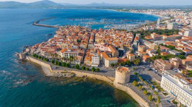 Sardinya 'daki eski Alghero kasabasının hava manzarası. Güneşli bir günde insansız hava aracıyla çekilmiş bir fotoğraf. Eski şehrin panoramik manzarası ve Alghero limanı, Sardunya, İtalya.