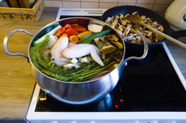 Elektrikli fırında paslanmaz çelik tencereyle seramik tavuklu tavuk çorbası. İçindekiler: sebze, tavuk, dolmalık biber, kereviz, pırasa, kereviz yaprağı, defne yaprağı, sarımsak, soğan, havuç..