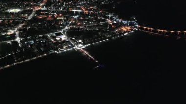 Büyüleyici bir insansız hava aracı filmi Koobrzeg 'in deniz feneri ve kış gecesi rıhtımını sergiliyor, sakin bir ortam ve büyüleyici gece ışıkları ile kıyı güzelliğini harmanlıyor. Kolobrzeg, Polonya.