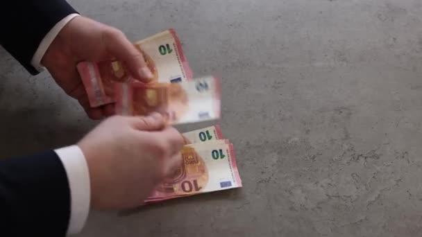 海軍のスーツと白いシャツの男は10ユーロ紙幣の束を数える — ストック動画