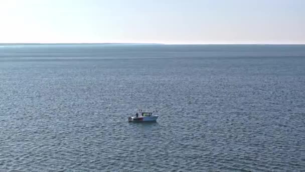ドローンはセリーンバルト海のシーンをキャプチャします 2月の晴れた日にコロブシェグ海岸近くのボートから釣る男 — ストック動画