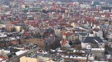 Ocak ayında Poznan, Polonya 'daki eski pazar meydanının insansız hava aracı görüntüleri. Karla kaplı çatılar, tarihi belediye binası ve turuncu çatıları olan eski meydandaki evler..
