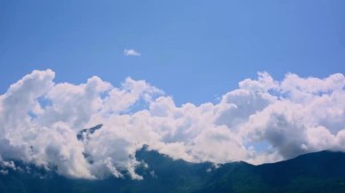 Lombardy 'nin dağlık arazileri, mavi gökyüzünü süpüren beyaz bulutları ve yükselen dağ zirvelerini gösteren bir zaman diliminde canlanır..