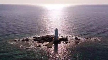 Sakin Sardunya denizlerine karşı kurulan Faro Mangiabarche deniz feneri, güneşin altında parlayan kahverengi kayalar, beyaz köpük ve mavi suların manzarasını sunuyor. İnsansız hava aracı tarafından ele geçirildi, mükemmel bir kıyı portresi..