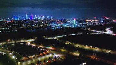 Parlayan metropolitan Swietokrzyski Köprüsü, hareketli otoyollar ve ufka doğru uzanan aydınlık şehir.