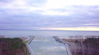 Vistula tükürük kanalı kışın, yukarıdan çekildi. Bir dron, engin Baltık Denizi ve gölün soğuk öğleden sonra havasında hareketsiz durduğu sakin sularda sürüklenen buzun güzelliğini yakalar..