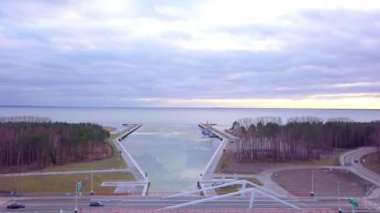 Vistula Tükürük Kanalı 'nın hava aracı görüntüleri. Baltık Denizi ve Vistula Gölü 'nün arka planında hem sakin hem de bulutlu gökyüzünü yansıtan buz kütleleri bozulmamış sularda sürükleniyor..