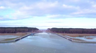 Vistula tükürük kanalı, kışın yukarıdan görüldü. Buz kütleleri sakin suyu süslerken, hem Baltık Denizi hem de Vistula Gölü rahatsız edilmeden duruyor, sessiz öğleden sonra gökyüzünü yansıtıyor..