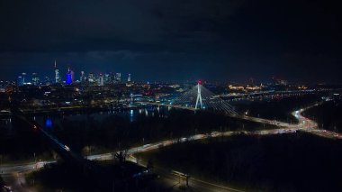 Varşova 'nın pırıl pırıl gökdelenleri, köprüler ve Wisa Nehri şehrin ışıklarını yansıtıyor..