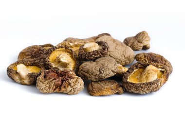 Beyaz arka planda düzgün bir şekilde düzenlenmiş, kurutulmuş shiitake mantarları karmaşık dokular ve derin organik renkler sergiliyor, kırsal mutfak mirası hissini çağrıştırıyor..