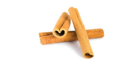 Tarçın kabuğu parçaları beyaz bir yüzeye dizilmiş, lifli dokularını, zengin kahverengi renklerini ve organik şekillerini vurguluyor, mutfak ve bitkisel sunumlar için mükemmel..