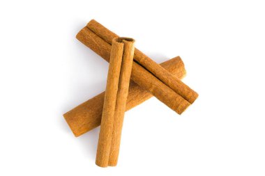 Çeşitli kurutulmuş tarçın kabuğu segmentleri beyaz üzerine serilmiş. Karmaşık desenlerini, kaba yüzeylerini ve derin kahverengi gölgelerini ortaya koyuyor. Yemek ve bitkisel betimleme için ideal..