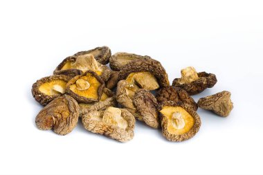 Bu canlı görüntü, geleneksel bir mutfak malzemesinin orijinalliğini sembolize ederek, kaba dokularını ve zengin toprak tonlarını yakalayan, beyaz üzerinde kurutulmuş shiitake mantarları barındırıyor..