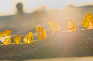 Günbatımı Kolobrzeg sahilini ısıtıyor, sarı ve bal rengi sarı kehribar taşlarını aydınlatıyor, parlak bir yaz parıltısıyla..