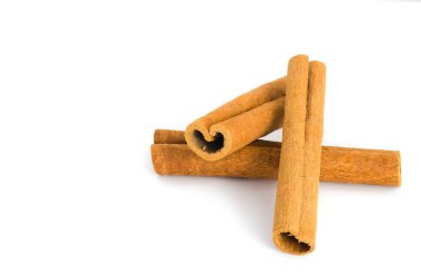 Beyaz arka planda düz tarçın kabuğu parçaları var. Kırsal görünüşlerini, lifli dokularını ve toprak renklerini vurguluyorlar. Yiyeceklerle ilgili görseller için uygun..