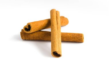 Tarçın kabuğu parçalarının beyaz bir zeminde toplanması, doğal güzelliklerini, kaba dokularını ve baharat özelliklerini yakalamak, mutfak tasvirleri için mükemmel..