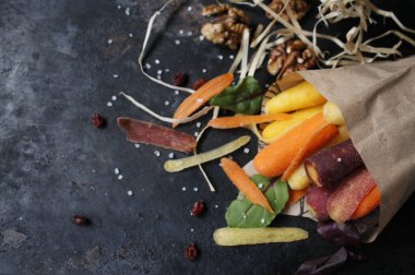 Kağıt zarfın içinde farklı renkte küçük havuçlar.