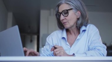 Üst düzey kadın grafik tasarımcısı dizüstü bilgisayarından iş projelerini kontrol ediyor ve gerçekten seviniyor, tasarımcıların en tepesine çıkıyor, değerli işler yapıyor.